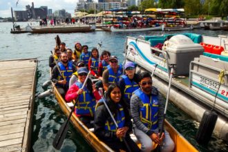 People out in a voyageur canoe with Harbourfront Canoe & Kayak Center