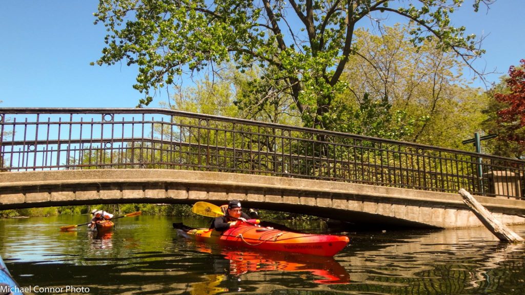 ducking under a low bridge in a kayak
